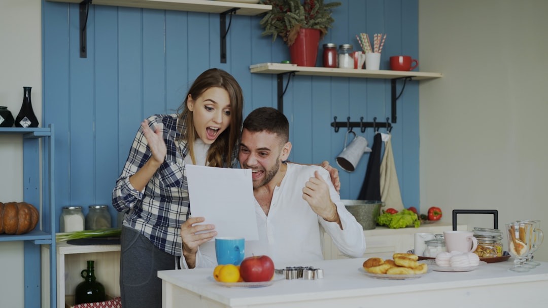 Couple celebrating good news while looking at paper.